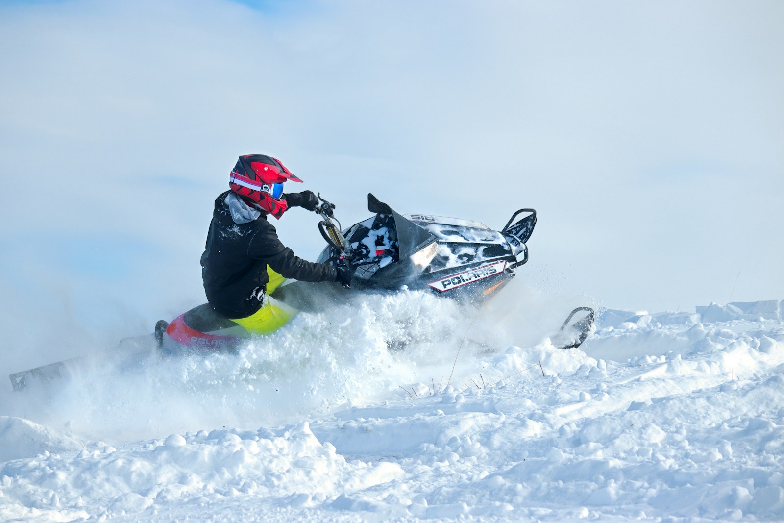 Rider carving a mountain sled through powder