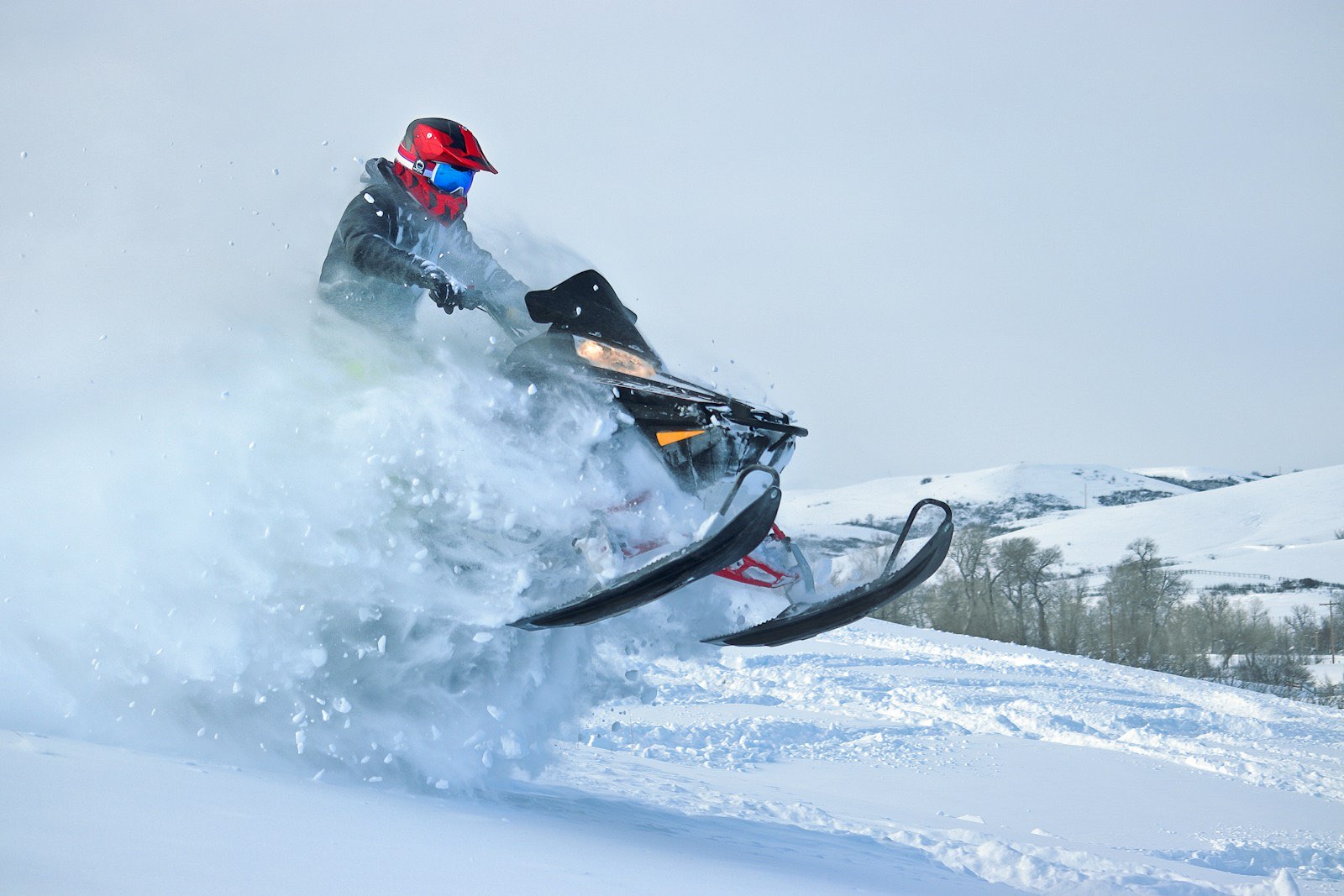 Snowmobiler blasting through deep powder